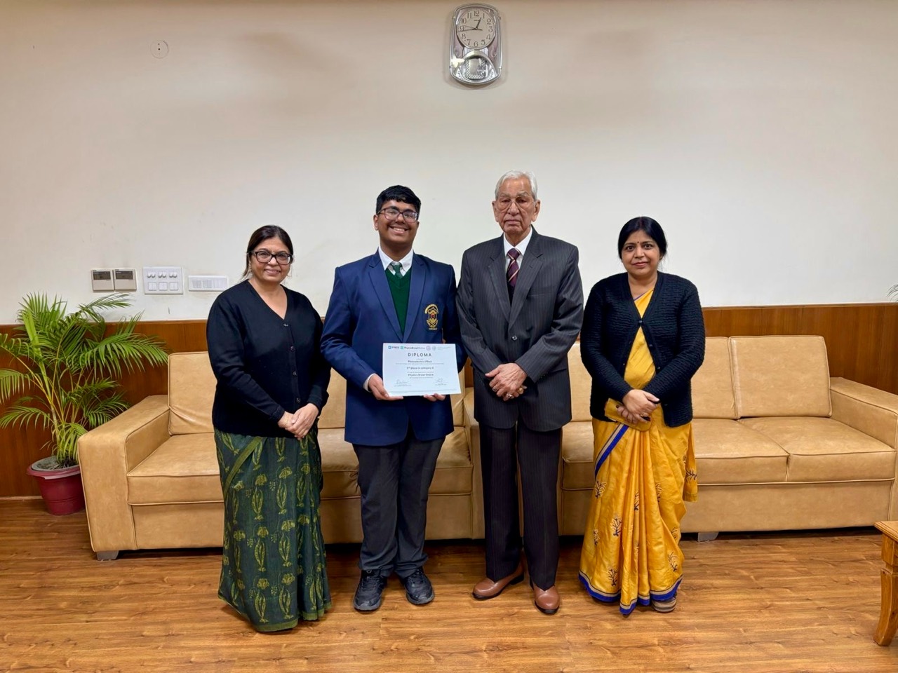 Ikshit receiving his Physics Brawl diploma with his school principal and teachers